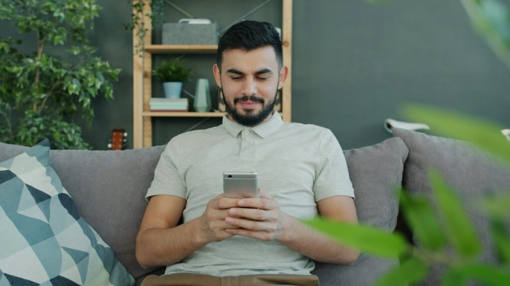 24 Month SIM Only Plans at a Lower Monthly Price Man relaxing on a sofa while using his smartphone