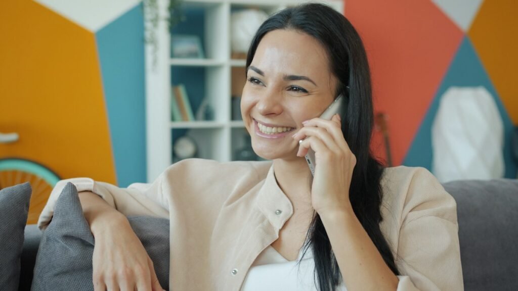 Smiling woman talking on her phone at home