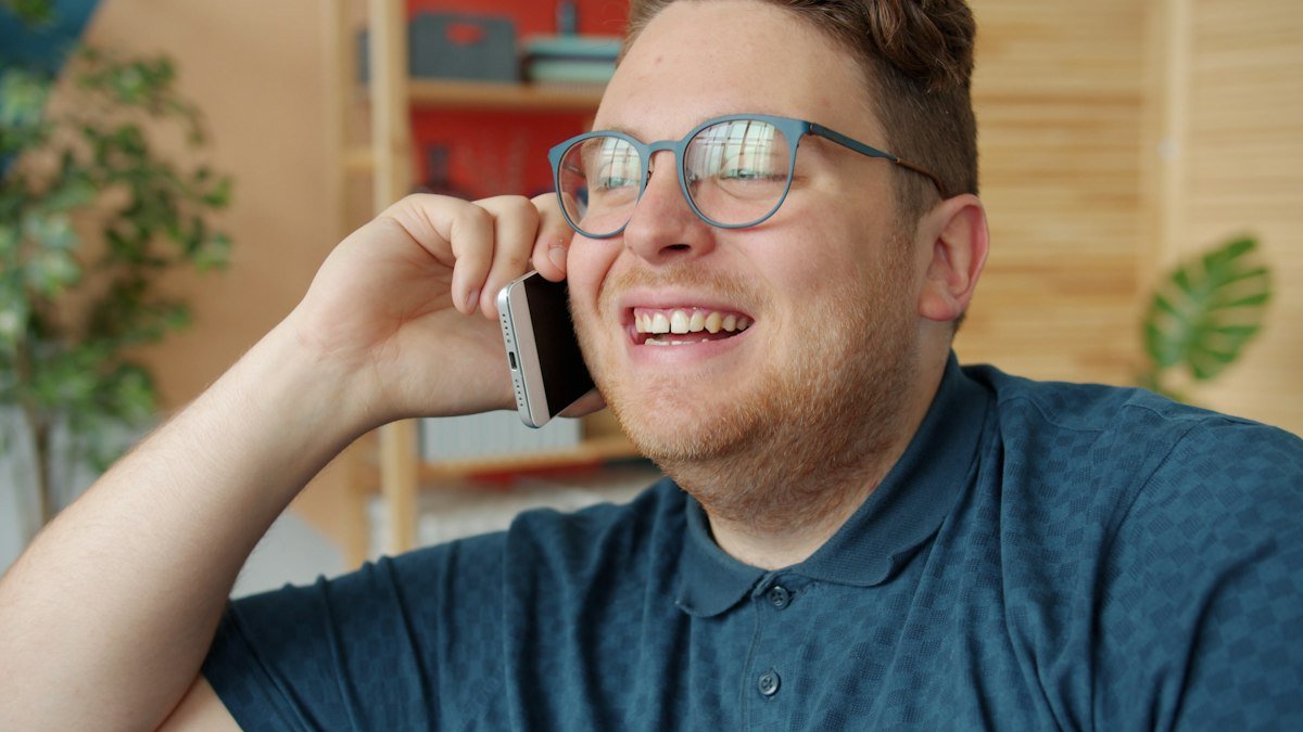 Man laughing during a phone call at home